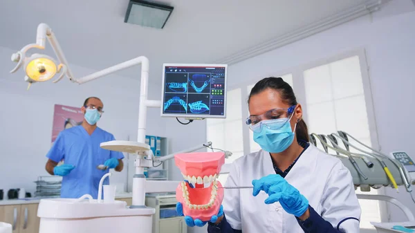 Пациент пова стоматолога показывает правильный способ чистки зубов — стоковое фото
