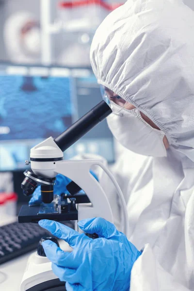 Medicinsk vetenskapsman analysera prov på glasskiva tittar genom mikroskop — Stockfoto