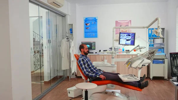 Enfermera invitando a paciente en sala de estomatología mostrando a acostarse en silla —  Fotos de Stock