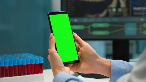 Chemik kontroluje výsledky pacientů na smartphonu se zelenou obrazovkou — Stock fotografie