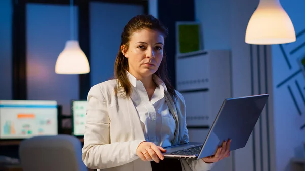 Exhausted business woman typing on laptop and sighing looking at camera — Stock Photo, Image