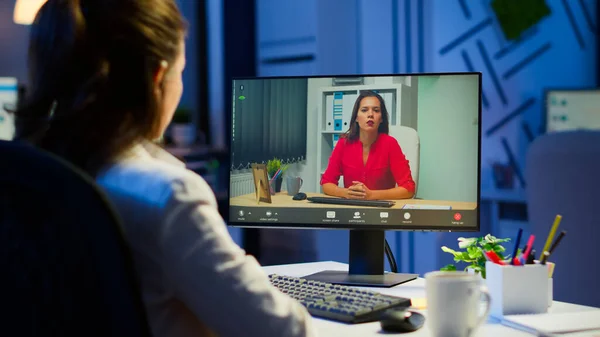 Gerente conversando com colega de trabalho durante videoconferência à meia-noite — Fotografia de Stock