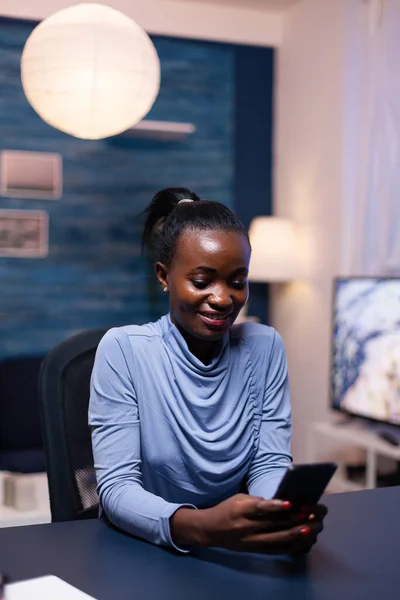 Vrolijke Afrikaanse vrouw sms 'en op smartphone — Stockfoto