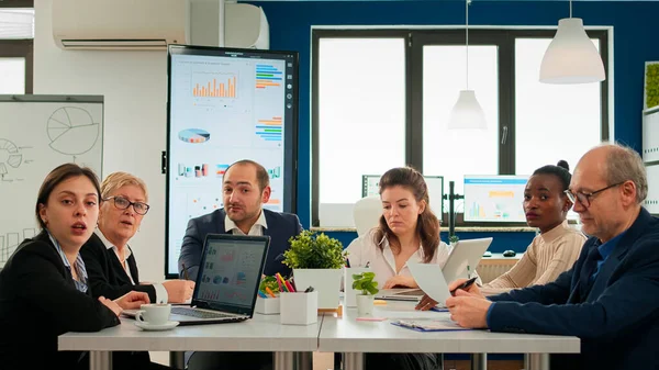 Ein bunt gemischtes Team sitzt während eines virtuellen Meetings im Konferenzraum — Stockfoto