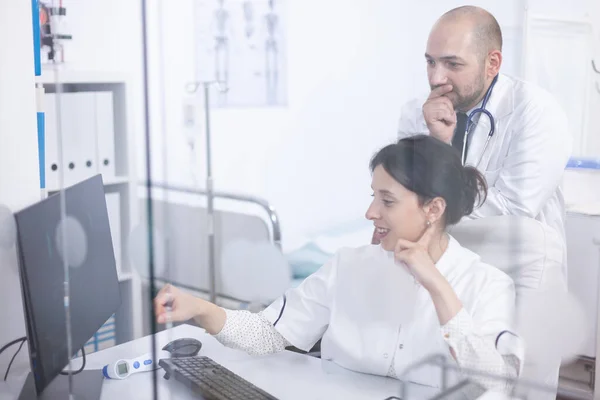 젊은 부부의 의사들이 컴퓨터로 의료 촬영을 분석하고 있다 — 스톡 사진