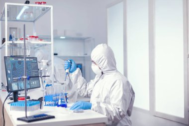 Araştırmacı otomatik pipetle numuneleri karıştırıyor.