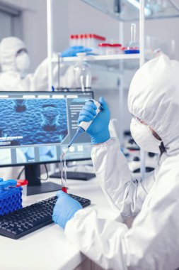 Bilim adamı mikro pipet kullanarak test tüpünden kan örneği alıyor.