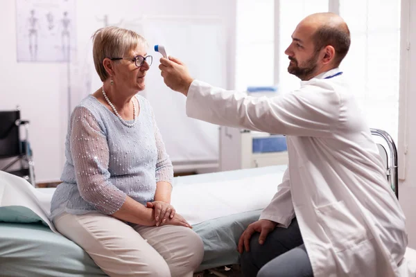 Medisch personeel met infrarood thermometer — Stockfoto