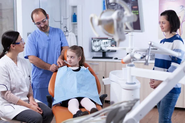 Врач-стоматолог говорит с родителем о гигине ротовой полости — стоковое фото