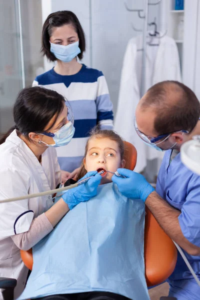 Child with mouth open looking at dentist assistant — Stock Photo, Image