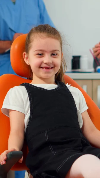 Портрет маленької дівчинки-пацієнта, який дивиться на камеру, чекає на дитячого стоматолога — стокове фото