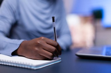 Koyu tenli bir kadının not almasına yakın durun.