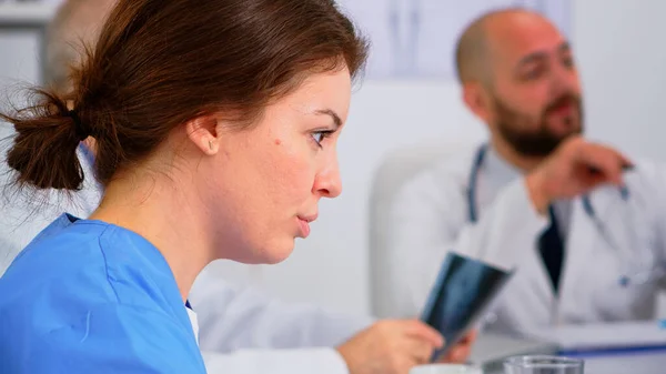 Крупним планом молода жінка медсестра обговорює з колегою — стокове фото