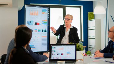 İstatistiksel veri sunan yaşlı proje yöneticisi,