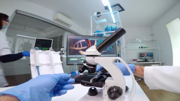 FPV del científico médico que mira bajo el microscopio, analiza la muestra de placas de Petri — Vídeos de Stock