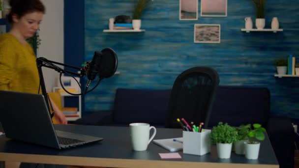 Retrato de un joven vlogger trabajando en un acogedor estudio, sonriendo a la cámara — Vídeos de Stock