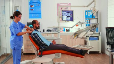 Hemşire stomatolojik muayeneden önce dişçi önlüğü takıyor.