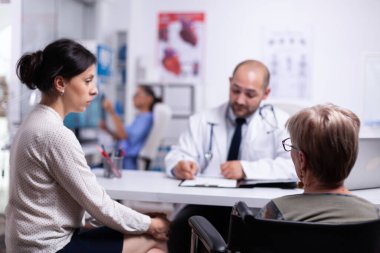 Doughter ve engelli anne danışma sırasında doktorla konuşuyor