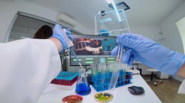 Bilim adamının test tüpünü sıvıyla doldurmak için mikro pipet kullanmasının FPV 'si