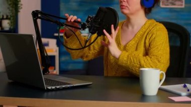 Podcaster, kulaklıkla stüdyoda online kayıt yapıyor.