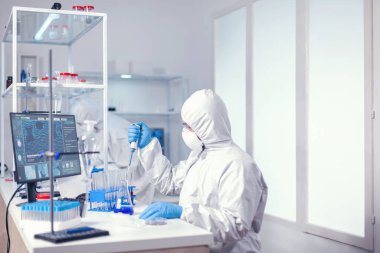 Doktor otomatik pipeti kullanarak test tüpünden örnek alıyor.