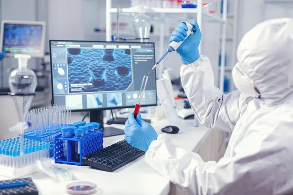 Medical engineer using dispenser to take sample of blood