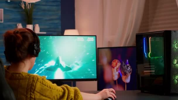 Mujer gamer concentrado sentado en el escritorio, con auriculares — Vídeos de Stock