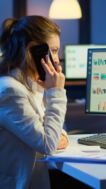 Sinir bozucu yönetici, akıllı telefonda fazla mesai yapan çalışanlarla konuşuyor.