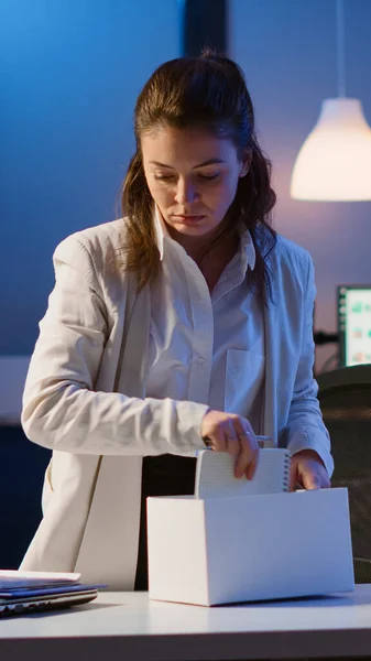 Sad businesswoman packing things in box being dismissed from job