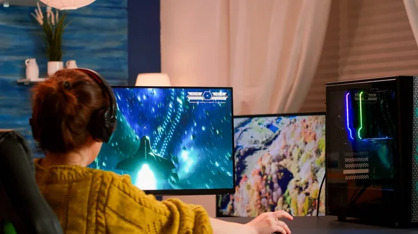 Geconcentreerde vrouw gamer zitten op het bureau, het dragen van headset — Stockfoto