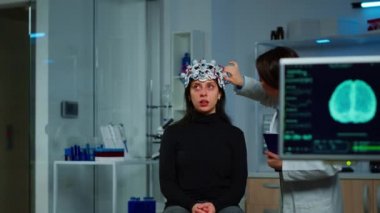 Nöroloji doktoru, tedaviyi açıklayan kulaklığı kontrol ediyor.