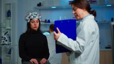 Hasta kadın, nöroloji doktorunun panoya bakmasını dinliyor.