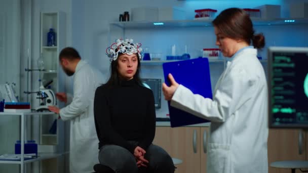 Investigador apuntando al portapapeles explicando el tratamiento contra las enfermedades cerebrales — Vídeos de Stock
