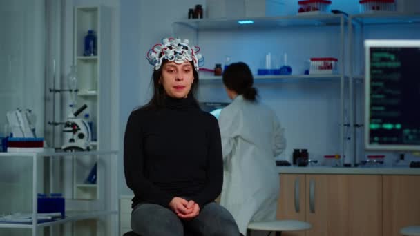 Medico ricercatore aggiustare cuffie EEG analizzando l'evoluzione dei pazienti — Video Stock