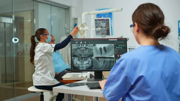 Hemşire bilgisayarın önünde dijital röntgen analizi yapıyor. — Stok fotoğraf