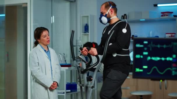 Esportista correndo em cross trainer em instalações de laboratório para o desempenho esportivo — Vídeo de Stock