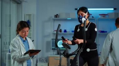 Maskeli bir kadın kalp atışlarını test ediyor.