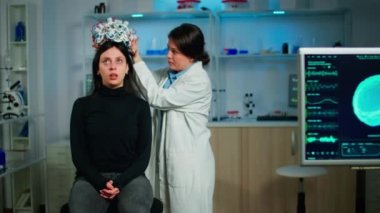 Tıbbi laboratuvar teknisyeni beyin fonksiyonlarını izleyen kulaklıkları ayarlıyor.