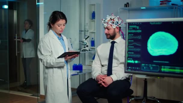 Spesialistlege i nevrovitenskap tar notater på skriveplaten – stockvideo