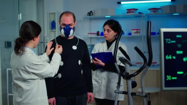 Vědec výzkumník připravuje muže pacienta na vytrvalostní test — Stock video