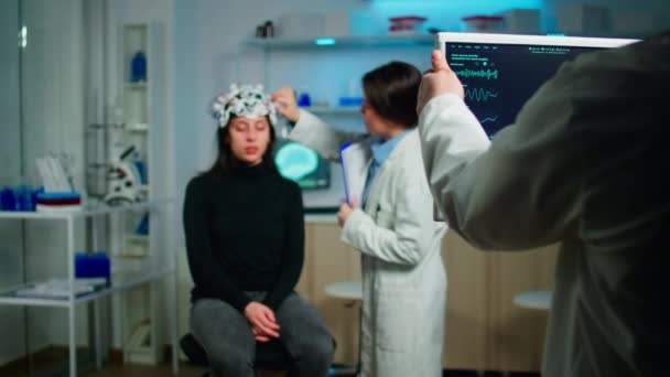Stressed patient sitting on neurological chair with eeg headset — Stock Video