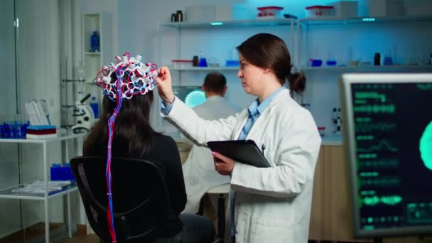 Visão traseira da paciente mulher usando varredura de onda cerebral performant — Vídeo de Stock