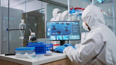 Bilgisayarda aşının evrimini analiz eden kimyager.