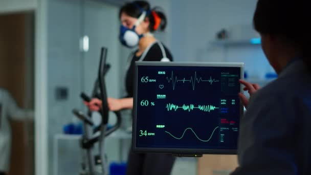 Lékařský vědec vyšetřující EKG obraz zobrazující na monitoru — Stock video