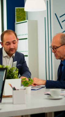 Takım elbiseli bir işadamı farklı iş ortaklarıyla konuşuyor.