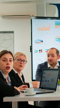 Çeşitli takımlar sanal toplantı sırasında konferans odasında oturuyorlar.