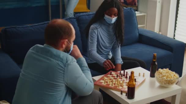Többnemzetiségű barátok sakkoznak az otthoni nappaliban társadalmi távolságot tartva — Stock videók