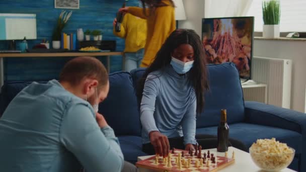 Diverse friends clinking bottles of beer playing chess at home — Stock Video