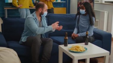 Covid19 'un yayılmasını önlemek için el dezenfektanı kullanan çok ırklı bir grup.