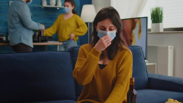 Young lady with protection mask in living room drinking beer — Stock Video